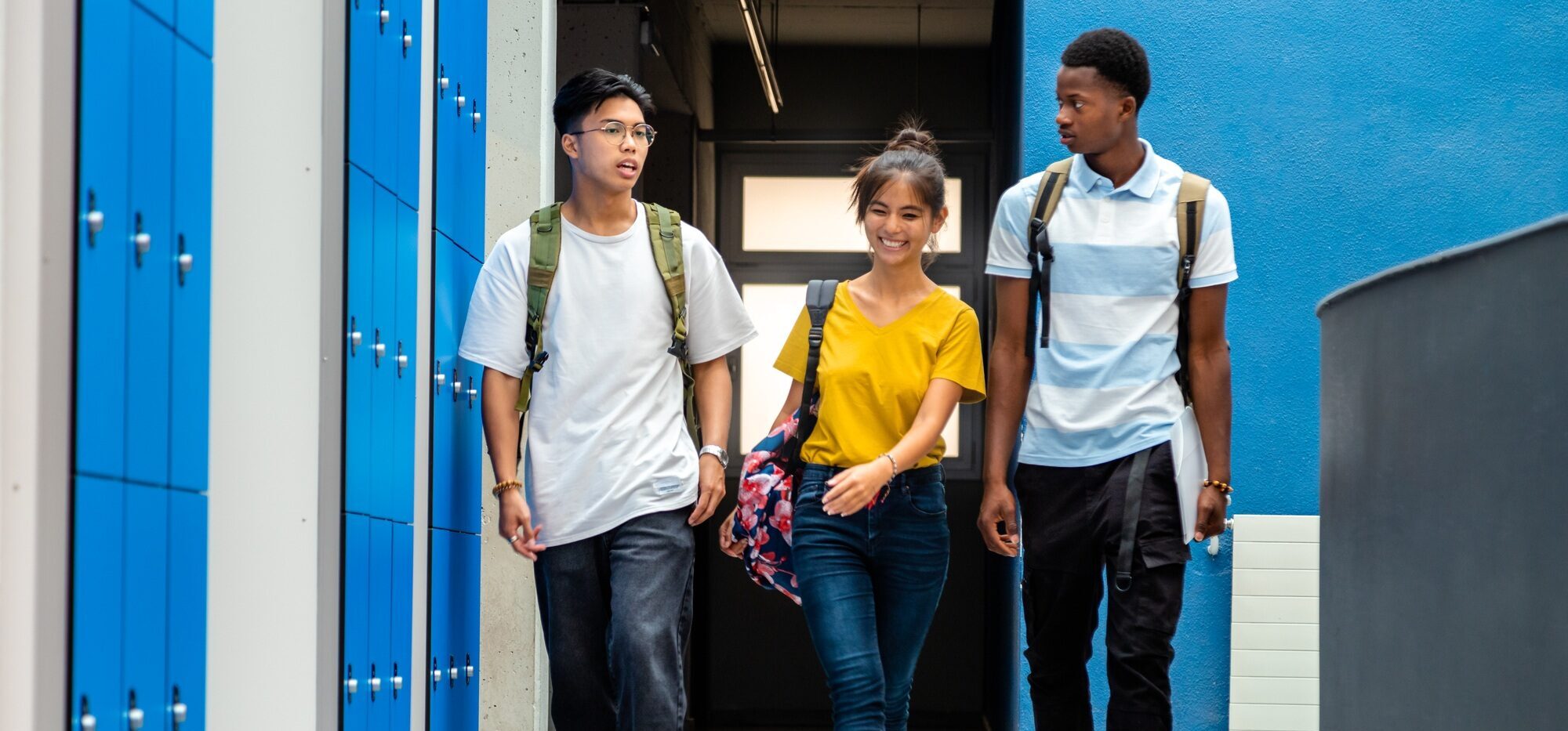 ultiracial teen high school students changing classes walking in school corridor. Back to school.
